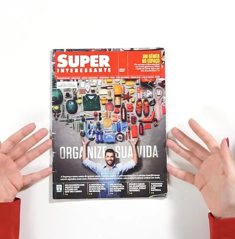 Mãos segurando uma revista com a capa “Organize sua vida”